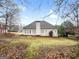 Back exterior view of home with stucco, windows, patio door, and lawn at 9135 Woodhaven Way, Mcdonough, GA 30253