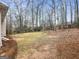 Backyard featuring a lawn with pine straw mulch, with an adjacent home in background and blue sky at 9135 Woodhaven Way, Mcdonough, GA 30253