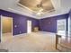 Expansive bedroom featuring tray ceiling, bright windows, and custom wall decor at 9135 Woodhaven Way, Mcdonough, GA 30253