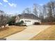 Exterior view of home, featuring an attached garage, stone accents, neutral siding and mature trees at 9135 Woodhaven Way, Mcdonough, GA 30253