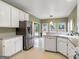 Well-lit kitchen featuring white cabinets, stainless steel refrigerator, and breakfast area at 9135 Woodhaven Way, Mcdonough, GA 30253