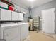 Functional laundry room with washer, dryer, storage cabinets, and utility sink at 9135 Woodhaven Way, Mcdonough, GA 30253