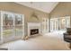 Living room with a fireplace, large windows, and an open layout to additional rooms at 9135 Woodhaven Way, Mcdonough, GA 30253