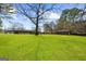 Spacious backyard featuring a large grassy area and mature trees at 2692 Fairview Rd, Covington, GA 30016