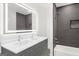 Modern bathroom features double vanity with sleek gray cabinets and bright, illuminated mirror and tiled shower and tub at 2692 Fairview Rd, Covington, GA 30016