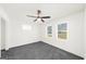 Bright bedroom with neutral carpet, ceiling fan, and two windows offering natural light. Spacious and ready for personal touches at 2692 Fairview Rd, Covington, GA 30016