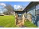 Front porch with wood stairs and railings of a home with dark gray brick and siding at 2692 Fairview Rd, Covington, GA 30016