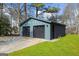 Detached two-car garage with modern design, neutral siding, and black garage doors, with a neatly maintained lawn at 2692 Fairview Rd, Covington, GA 30016