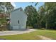 Home's exterior featuring a two-car garage, a well-manicured lawn, and a private, wooded backyard at 230 Wyngate Cir, Fayetteville, GA 30215