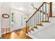 Welcoming foyer with hardwood floors, staircase, and a white front door with glass inserts at 230 Wyngate Cir, Fayetteville, GA 30215