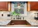 Close-up of a kitchen sink featuring granite countertops and modern fixtures at 230 Wyngate Cir, Fayetteville, GA 30215
