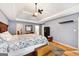 Comfortable main bedroom with tray ceiling, ceiling fan, and hardwood floors at 230 Wyngate Cir, Fayetteville, GA 30215