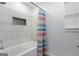 Bathtub with a shower curtain and built-in tiled shelf on the wall at 3973 Laurel Bend Dr, Snellville, GA 30039