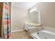 A bright bathroom with double sinks, a tub, and a large mirror for shared morning routines at 3973 Laurel Bend Dr, Snellville, GA 30039