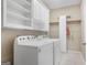 The laundry room features a front-loading washer and dryer with shelving for storage at 3973 Laurel Bend Dr, Snellville, GA 30039