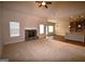 Spacious living room with stone fireplace, carpet floors, and kitchen view at 175 Osier Dr, Mcdonough, GA 30252