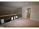 Spacious loft area featuring a decorative iron railing and neutral carpeting at 175 Osier Dr, Mcdonough, GA 30252