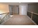 Loft area with carpet, wrought iron railing, and overhead lighting at 175 Osier Dr, Mcdonough, GA 30252