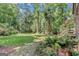 Secluded backyard featuring a stone walkway, lush greenery, and an inviting green lawn at 5200A Burruss Mill Rd, Cumming, GA 30041