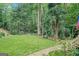 Lush backyard featuring a stone pathway leading to a tranquil green space, surrounded by trees at 5200A Burruss Mill Rd, Cumming, GA 30041