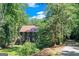 Charming two-story home with a red roof nestled among lush greenery, offering privacy and a serene setting at 5200A Burruss Mill Rd, Cumming, GA 30041