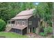 Exterior view of the home highlighting its unique architecture, back porch, and serene wooded surroundings at 5200A Burruss Mill Rd, Cumming, GA 30041
