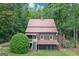 Exterior view of the home highlighting its unique architecture, back porch, and serene wooded surroundings at 5200A Burruss Mill Rd, Cumming, GA 30041