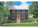Charming two-story home featuring a red front door, a metal roof, and beautifully landscaped front yard at 5200A Burruss Mill Rd, Cumming, GA 30041
