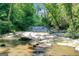 Scenic shot of a natural water feature flowing over rocks in a lush, green wooded area at 5200A Burruss Mill Rd, Cumming, GA 30041