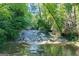 Natural water feature flowing through a wooded area, offering a tranquil and picturesque setting at 5200A Burruss Mill Rd, Cumming, GA 30041