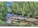 Scenic shot of the waterfall feature on the property, surrounded by lush greenery at 5200A Burruss Mill Rd, Cumming, GA 30041
