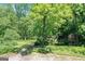 Lush green yard featuring mature trees and shrubs, adding to the property's charm and curb appeal at 5200A Burruss Mill Rd, Cumming, GA 30041