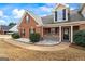 Close-up of a well-maintained brick home with a charming front porch, manicured shrubs, and meticulous landscaping at 115 Stewart Hollow Ln, Covington, GA 30016