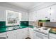 Kitchen with white cabinets, green countertops, and modern fixtures for a functional cooking space at 334 Nancy Sw Ct, Lilburn, GA 30047