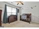 Cozy Bedroom with a dark wood crib, dresser, ceiling fan, and natural light at 208 Clifton Ln, Peachtree City, GA 30269