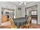 The dining room features wood floors, a chandelier, and an entrance to the living room and kitchen at 208 Clifton Ln, Peachtree City, GA 30269