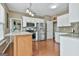 Spacious kitchen featuring white cabinets, stainless steel appliances, a kitchen island, and granite countertops at 208 Clifton Ln, Peachtree City, GA 30269