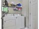 This laundry room features white appliances, storage shelves, and a door that adds a touch of functionality at 208 Clifton Ln, Peachtree City, GA 30269