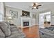 Cozy living room with a fireplace, hardwood floors, and a ceiling fan at 208 Clifton Ln, Peachtree City, GA 30269