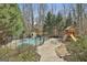 Backyard with a fenced pool area for safety, surrounded by mature trees and lush landscaping at 208 Clifton Ln, Peachtree City, GA 30269