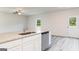 Kitchen island with granite countertop, stainless steel dishwasher, and white cabinets at 279 Limestone Cir, Conyers, GA 30013