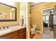 Neutral bathroom with tile floor, granite counters, wood cabinets, and a decorative framed mirror at 545 Mountains Edge, Peachtree City, GA 30269