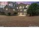 Twilight view of the backyard, with a spacious patio area and manicured lawn enhanced for evening entertainment at 256 Allie Dr, Mcdonough, GA 30252