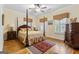 Bedroom featuring a four post bed, shuttered windows, and hardwood flooring at 256 Allie Dr, Mcdonough, GA 30252