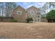 Spacious backyard with a large lawn and a brick house, providing ample outdoor space for activities at 256 Allie Dr, Mcdonough, GA 30252