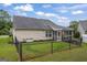 Backyard featuring a black metal fence, lawn, and the rear exterior of the house at 410 Mockingbird Dr, Loganville, GA 30052