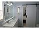 This bathroom boasts a sliding barn door, double vanity, and an illuminated mirror at 410 Mockingbird Dr, Loganville, GA 30052