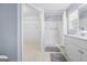 Bathroom with a vanity, framed mirror, tile flooring, and a walk-in shower at 410 Mockingbird Dr, Loganville, GA 30052