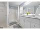 Bright bathroom featuring a double vanity, framed mirror, and walk-in shower at 410 Mockingbird Dr, Loganville, GA 30052