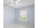 A light blue bedroom with a ceiling fan, a window with blinds, and tile flooring at 410 Mockingbird Dr, Loganville, GA 30052